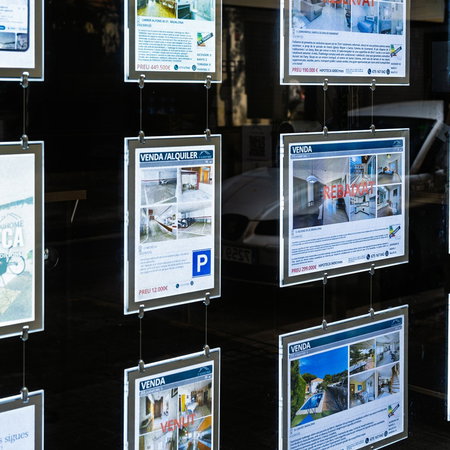 Property listings displayed in the window of a Spanish estate agency, as Spain's Tax Agency launches inspections into suspected tax fraud in the real estate sector.