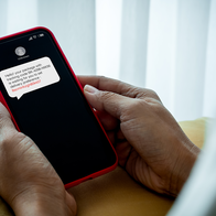 Person viewing a suspicious scam text message on a mobile phone in Spain