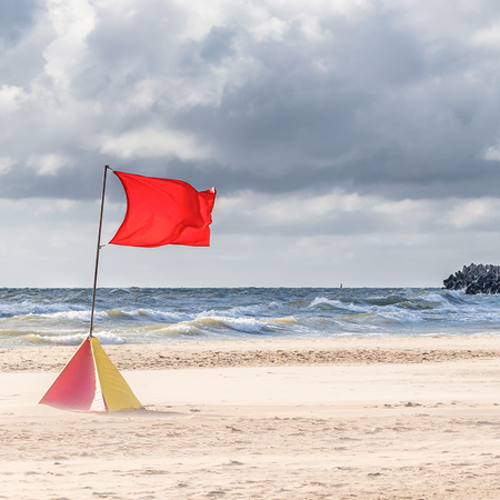 Warning flag on beach in rough conditions.
