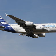 An Airbus A380 passenger aircraft in flight with its landing gear down during approach.
