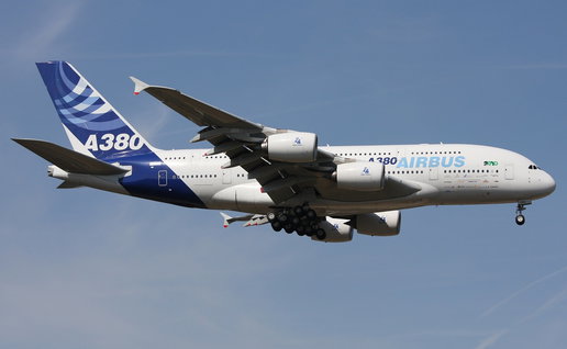 An Airbus A380 passenger aircraft in flight with its landing gear down during approach.
