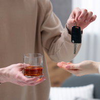 Driver hands over car keys after drinking alcohol, highlighting the importance of responsible driving.