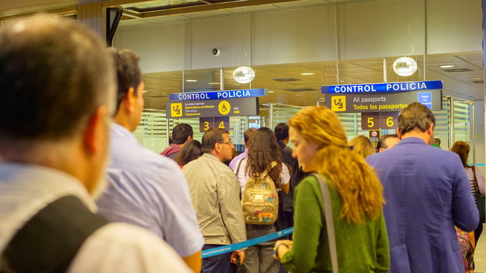 Travellers queue at passport control in a Spanish airport terminal as Europe prepares for new border checks.