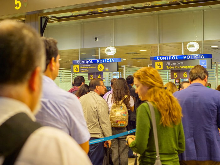 Travellers queue at passport control in a Spanish airport terminal as Europe prepares for new border checks.