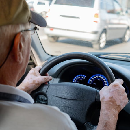An older driver behind the wheel of a car, illustrating Spain's licence renewal and medical assessment rules for motorists over 65.