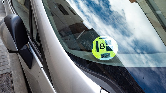 DGT environmental sticker displayed on a car windscreen in Spain.