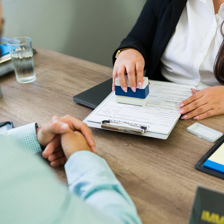 A foreign resident meets with an immigration adviser to review residency paperwork and official documents in Spain.