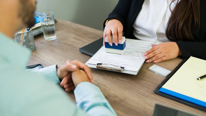 A foreign resident meets with an immigration adviser to review residency paperwork and official documents in Spain.