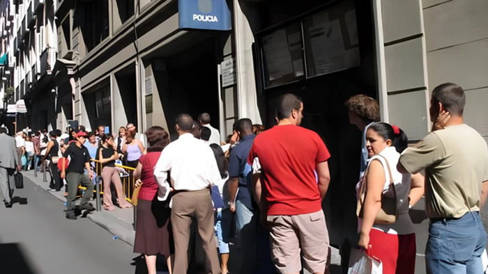 People queue outside an immigration office in Spain as uncertainty grows over the government's migrant regularisation plan.