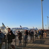 Passengers queue to board Ryanair aircraft on the airport apron as the airline expands its European route network for summer 2026.