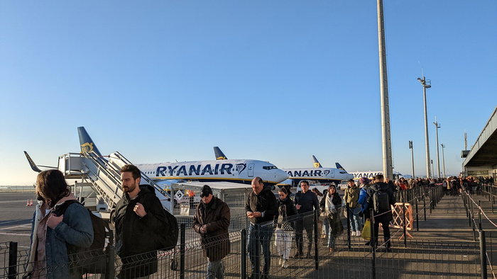 Passengers queue to board Ryanair aircraft on the airport apron as the airline expands its European route network for summer 2026.