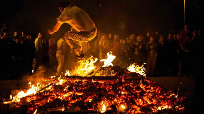 Person jumping over a San Juan bonfire during traditional midsummer celebrations in Spain on the night of June 23.