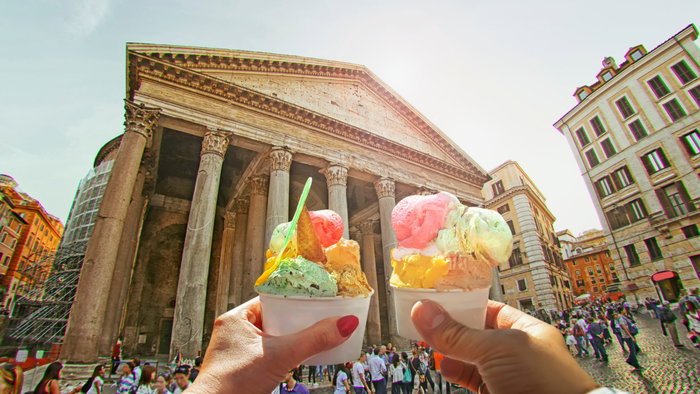 Couple holding up two ice creams by the Pantheon in Rome