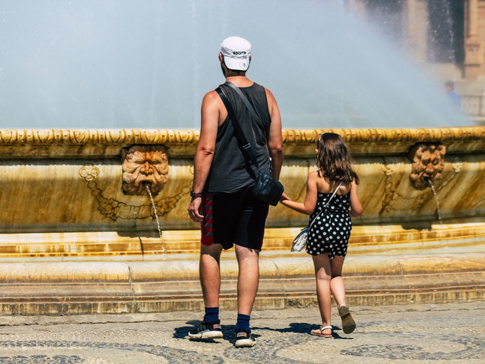 Father and daughter near a fountain in Seville
