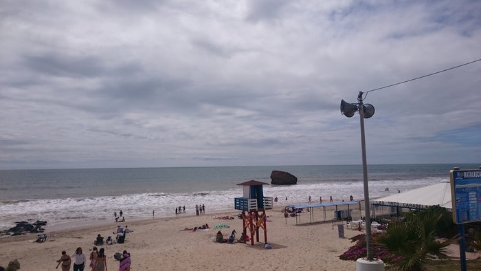 Warm enough for the beach, with some cloud cover.