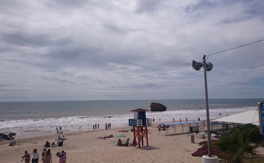 Warm enough for the beach, with some cloud cover.