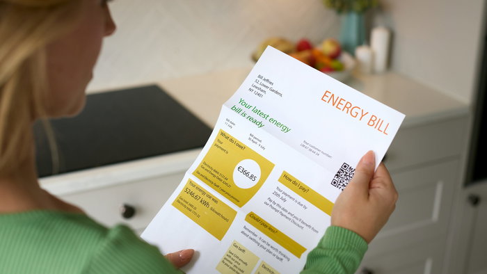 A woman looking at an energy bill receipt