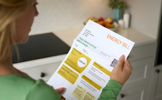 A woman looking at an energy bill receipt