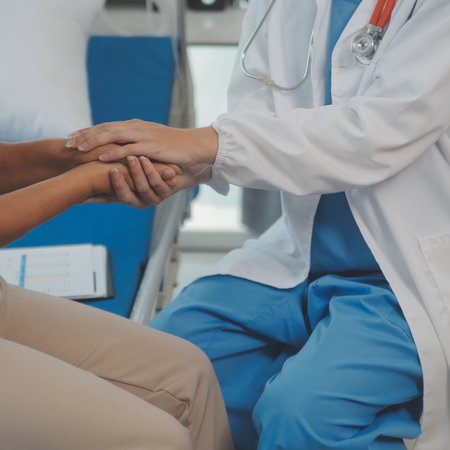 A female doctor holding a female patients hand