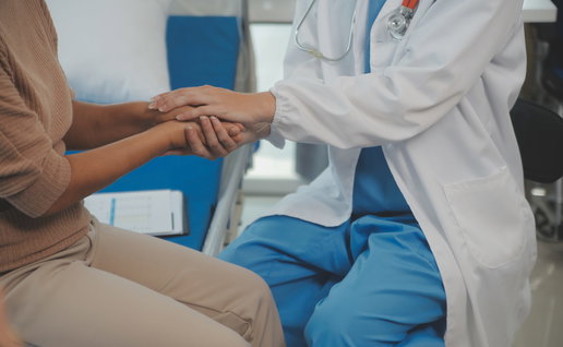A female doctor holding a female patients hand