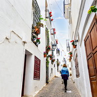 Blonde woman with curly hair walking through the streets of the picturesque town in Spain