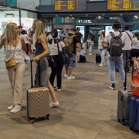Passengers waiting in train station for information on their train