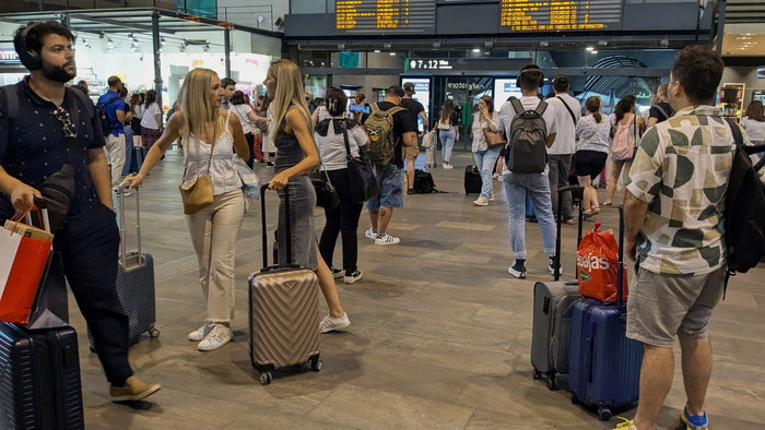 Passengers waiting in train station for information on their train