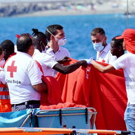 Irregular immigrants arriving at a port and being cared for bt the Red Cross