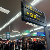 A busy airport with a baggage collection sign