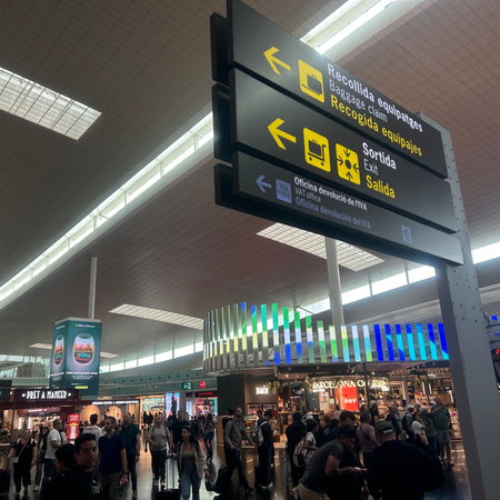 A busy airport with a baggage collection sign