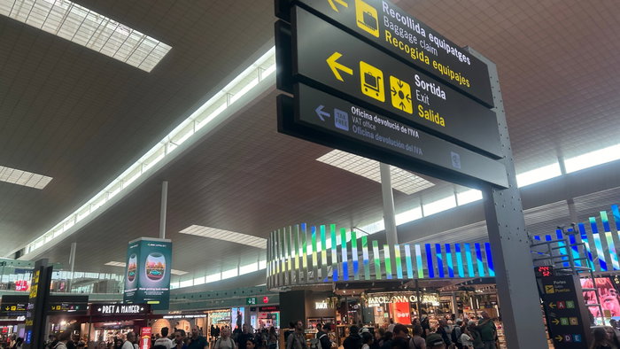 A busy airport with a baggage collection sign