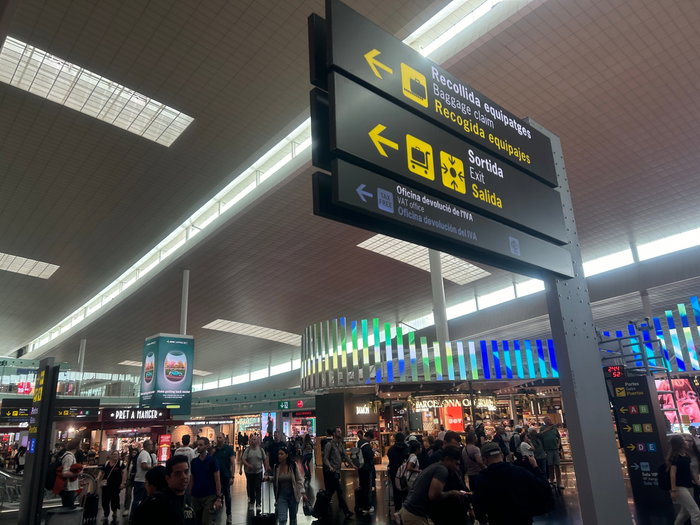 A busy airport with a baggage collection sign