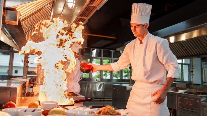 Professional chef cooking in a restaurant kitchen.