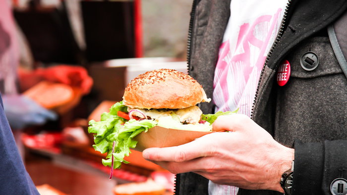Man holding a burger at a festival