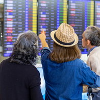 Passengers check flight information screens at an airport amid changes to EU airline passenger rules.
