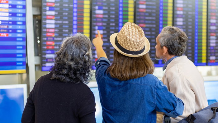 Passengers check flight information screens at an airport amid changes to EU airline passenger rules.