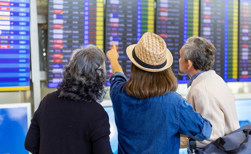 Passengers check flight information screens at an airport amid changes to EU airline passenger rules.