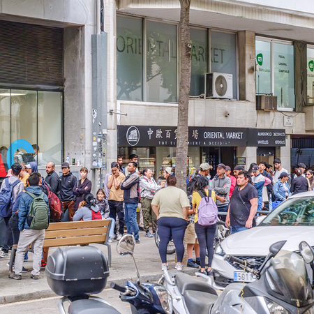 Large queue of people outside an administrative office in Spain.