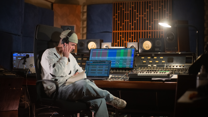 Music producer wearing headphones in a studio.