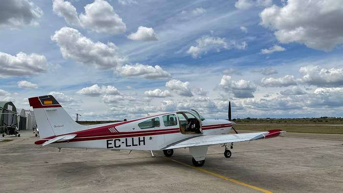 Small aircraft beside hangars and the runway at Casarrubios aerodrome.