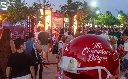 Visitors queue outside food trucks at The Champions Burger festival in Parque de la Estación, Almería.