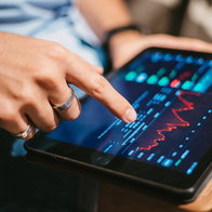 Young man checking stock market on a tablet