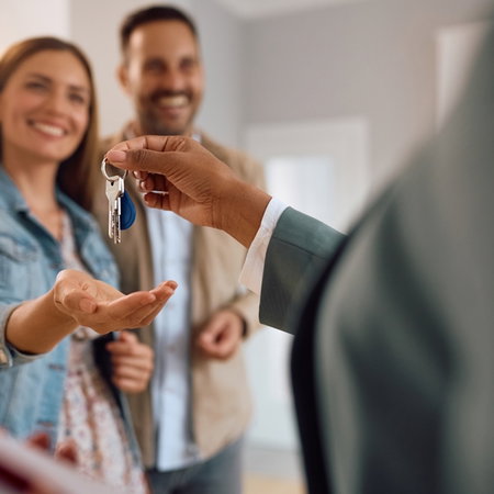 Close up of happy couple receiving keys of their new home in Spain from real estate agent.
