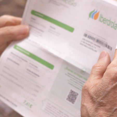 Man holding a Spanish Iberdrola invoice.