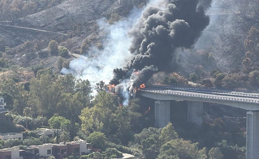 Flames and black smoke rise from a burning fuel tanker on an AP-7 bridge near Benahavís and Estepona.