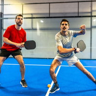 2 active men playing a pickleball match