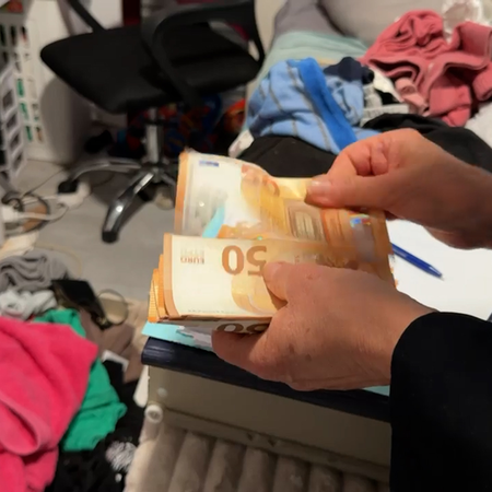 A person counts €50 banknotes in a room during the Guardia Civil investigation.