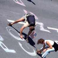 People drawing on asphalt.