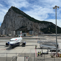 Aircraft on runway at Gibraltar airport with rock in the background.