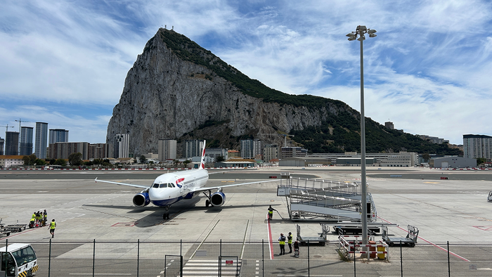 Aircraft on runway at Gibraltar airport with rock in the background.